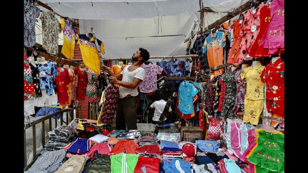 A Man Arranges Clothes At His Shop In A Wholesale 1734360408663.jpg